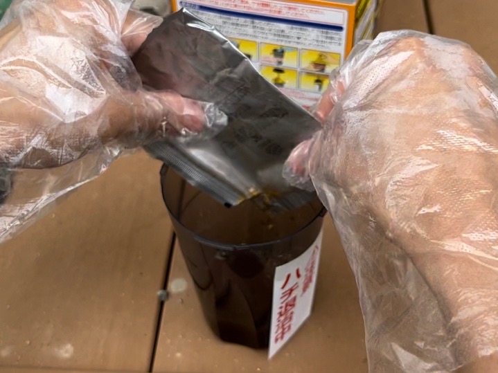 アース製薬の蜂捕獲器の容器の目盛りラインまで水を加える様子