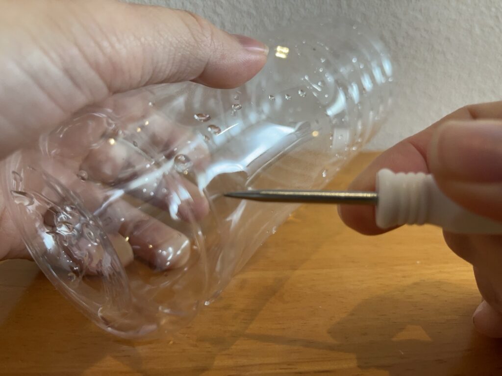 ペットボトル側面に小さな穴を開ける様子