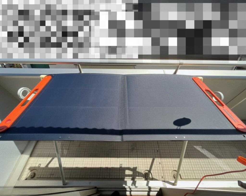 布団干し台の上に水平に設置したJackery SolarSaga 100W。日当たりが悪いベランダで、高い位置の太陽光を効率よく受けるための工夫。