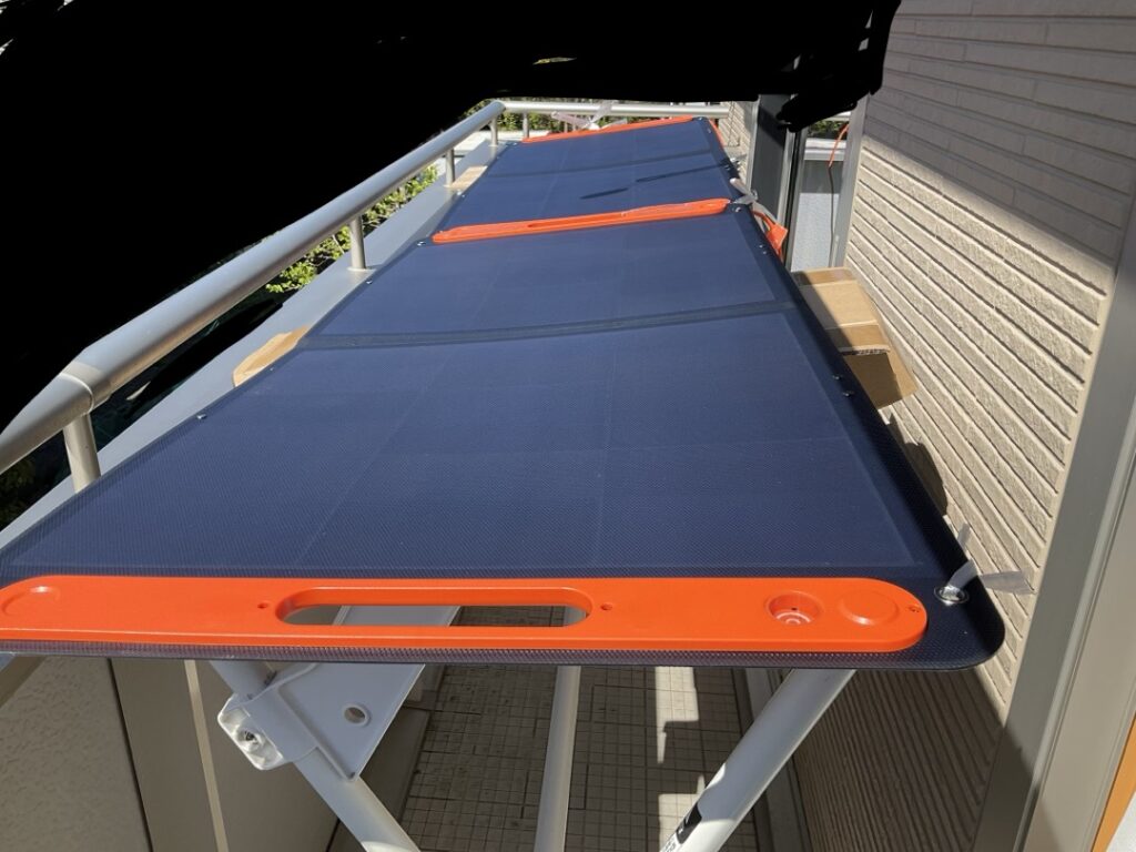 ベランダの洗濯物干し台の上に、Jackery SolarSaga100を2枚並べて設置している様子。日当たりの良い位置にパネルを置き、発電実験を行っている状況が分かる写真。