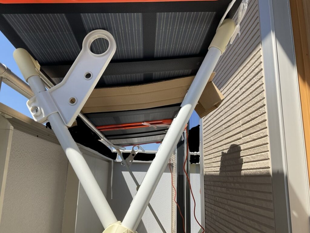 Jackery SolarSaga100の裏側を撮影した写真。パネルが自重でたわまないよう、中央部分を段ボールで支えて補強している様子が写っている。