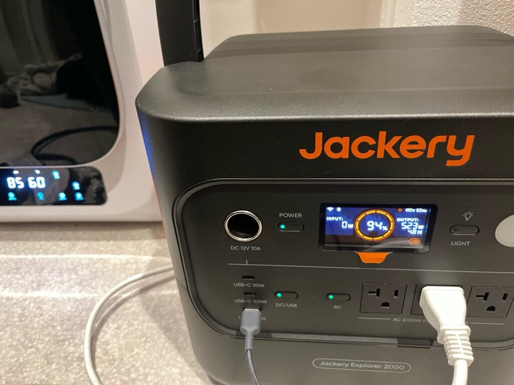 Jackery 2000 New に衣類乾燥機を接続して使用している様子を撮影した写真。実際に家電を動かしている状態が分かる構図。